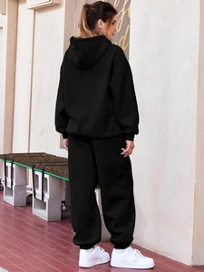Detail of black hooded sweatshirt and jogger pants set in premium cotton knit fabric