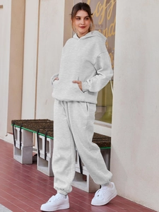 Detail of grey hooded tracksuit featuring drop shoulder design and ribbed cuffs