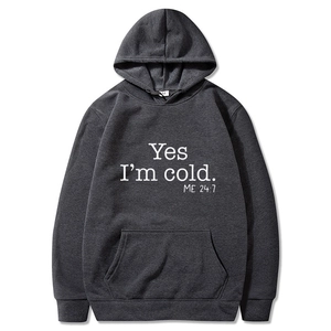 Detail of dark grey hoodie featuring white 'Yes I'm cold' print and kangaroo pocket