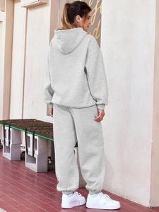 Rear view of a light grey two-piece tracksuit featuring a loose hoodie and jogger pants