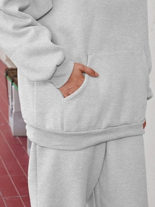 Detailed view of the gray marl fabric texture and kangaroo pocket on a casual tracksuit hoody