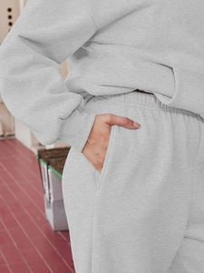 Detailed macro view of the grey knitted fabric texture and side pocket on matching joggers