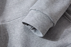 Detail view of ribbed cuffs and kangaroo pocket stitching on a grey hoodie