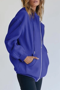 Detail of royal blue oversized zip hoodie featuring ribbed cuffs and side pockets