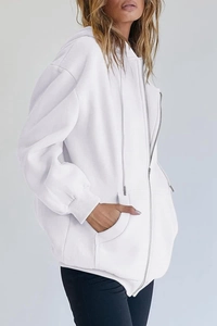 Close-up of oversized white zip-up hoodie with drawstring hood and large front pockets