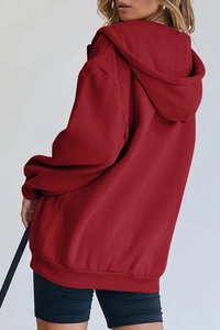 Detail view of oversized burgundy hoodie with ribbed cuffs and drop shoulder design