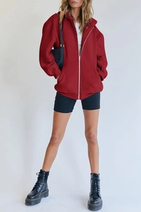 Detail of dark red oversized zip-up hoodie featuring drop shoulders and large front pockets