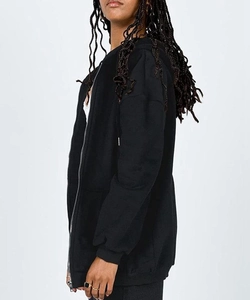 Close-up of black zip-up hoodie featuring silver zipper and ribbed cuffs on side view