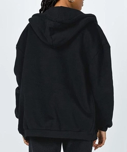 Detail view of the back of a black oversized hoodie with ribbed hem and drop shoulder