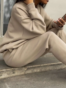 Macro detail of ribbed cuffs and thick knit fabric on beige oversized tracksuit
