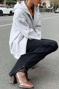 Detail of oversized grey zip-up hoodie paired with black side-slit flare pants