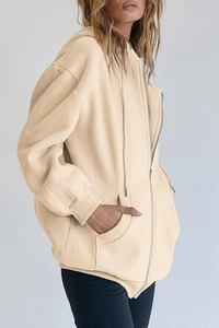 Detail of beige oversized zip-up hoodie featuring ribbed cuffs and soft fleece fabric