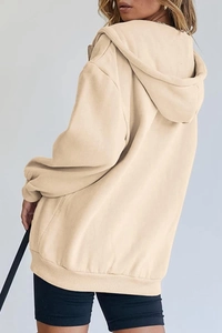 Detail of oversized cream hoodie featuring a zip-up front and ribbed sleeve cuffs