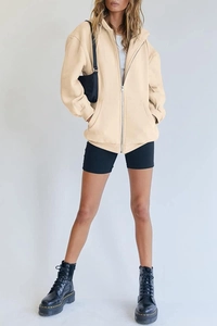 Detail of oversized cream zip-up hoodie with drawstring hood and front pockets for women
