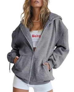 Close-up of a grey oversized zip-up hoodie with drawstring and functional front pockets