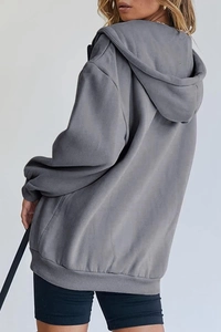 Detail of grey oversized hoodie showing drop shoulder seam and ribbed hem texture