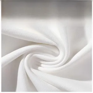 Detailopname van witte katoenen stof met fijne gebreide textuur en zachte ribbels