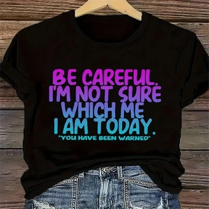 Dettaglio della t-shirt nera in cotone con stampa slogan sfumata viola su gruccia in legno