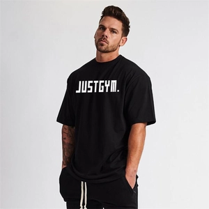 Detail of oversized black fitness t-shirt featuring the white JUSTGYM graphic print
