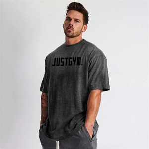 Detail of oversized dark grey gym t-shirt featuring JUSTGYM text and drop shoulder cut