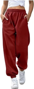 Detail of high-waisted deep red oversized sweatpants with elastic cuffs and side pockets