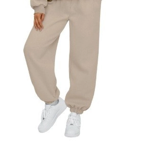 Detail of light oatmeal high-waisted joggers featuring elastic cuffs and fleece material