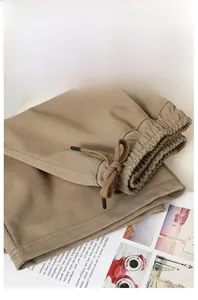 Detail of light khaki wide-leg sweat shorts featuring an elastic drawstring waistband