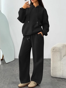 Detail of black oversized hoodie with drawstring and matching wide-leg sweatpants set