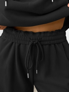 Detail of elastic waistband on black lounge pants with metallic tipped drawstring cord