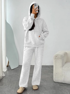 Women's light grey two-piece tracksuit set with oversized hoodie and wide-leg sweatpants