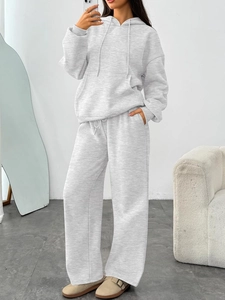 Detail of grey hooded sweatshirt with drawstring and kangaroo pocket and wide-leg sweatpants