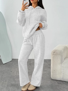 Detail of light gray knitted hoodie set featuring drawstring hood and wide-leg sweatpants