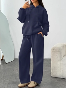 Detail of navy blue hoodie with kangaroo pocket and matching wide-leg lounge pants