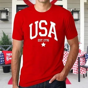 Gros plan du t-shirt rouge USA EST.1776 en coton porté par un mannequin en extérieur