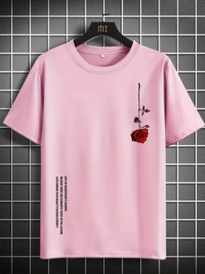Détail d'un t-shirt rose en coton avec motif de rose rouge et design de texte graphique