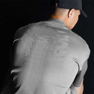 Close-up of grey mesh fabric texture on men's quick-dry breathable fitness t-shirt