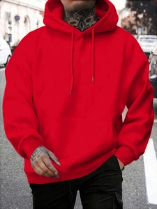 Detail of red oversized hoodie featuring kangaroo pocket and adjustable drawstring hood