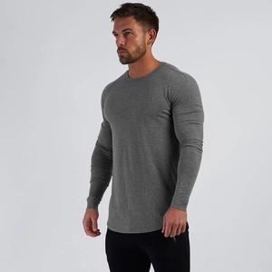 Dettaglio dell'orlo curvo e vestibilità slim sulla maglia sportiva grigia a maniche lunghe