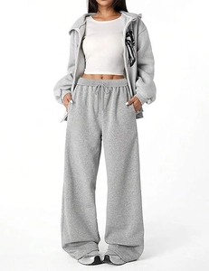 Detail of light grey high-waisted wide leg trousers with adjustable drawstring and pockets