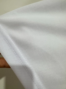 Close-up of white mesh fabric texture with high-quality double-needle stitching detail