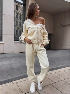 Dettaglio di una tuta sportiva color crema con felpa con cappuccio e pantaloni jogger