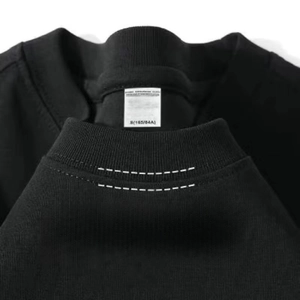 Vista macro del cuello redondo y la etiqueta de talla en una camiseta de algodón negro