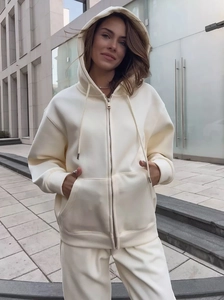 Dettagli della tuta sportiva bianco crema con cerniera in metallo e cappuccio con coulisse