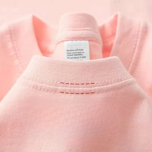 Primer plano del cuello de camiseta rosa con detalles de costura de doble aguja fina