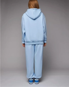 Vista posteriore di una tuta sportiva da donna azzurra con felpa e pantaloni jogger