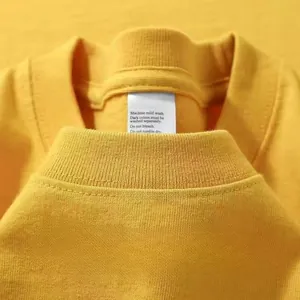 Primer plano del cuello redondo amarillo con ribete acanalado y costura reforzada