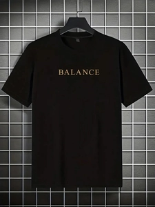 Détail du lettrage BALANCE doré imprimé sur un t-shirt noir en coton épais à col rond