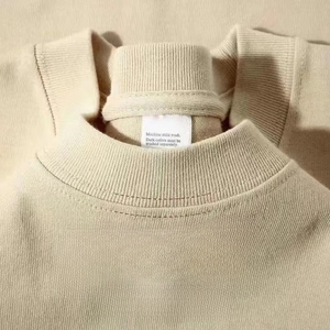 Detalle del cuello redondo acanalado en camiseta de algodón beige con costura doble