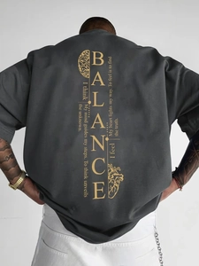 Détail du texte doré BALANCE et imprimé cerveau-cœur sur t-shirt en coton anthracite épais