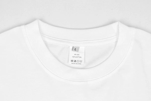 Vista macro dettagliata dell'etichetta in cotone 100% e dello scollo su una t-shirt bianca